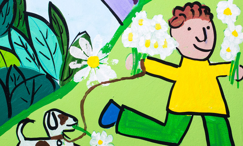 A child and dog walking through flowers 