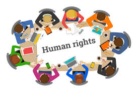 Table with human rights written on it and people sat around it. 