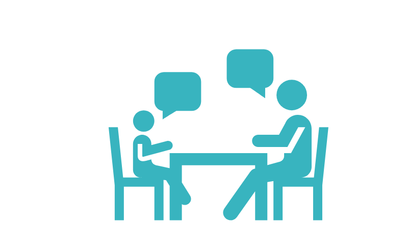 A child and adult sat at a table talking 